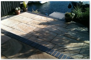 Multi level indian sandstone paving leading to waters edge at Hythe Marina, Hampshire